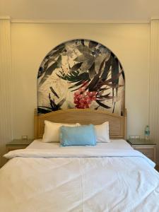 a large white bed with a painting on the wall at Sea Breeze, Guhagar in Guhagar
