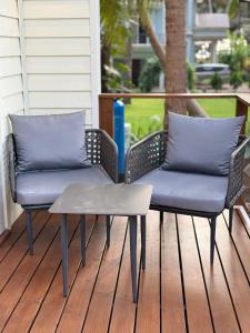 two wicker chairs and a table on a porch at Sea Breeze, Guhagar in Guhagar