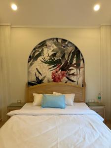 a bedroom with a large bed with a painting on the wall at Sea Breeze, Guhagar in Guhagar