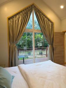 a bedroom with a bed and a large window at Sea Breeze, Guhagar in Guhagar
