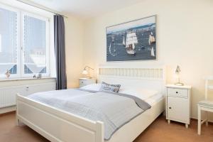 a bedroom with a white bed and a large window at Hafen 13 Hafenblick 1 in Laboe