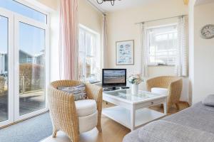 a room with a desk with a computer and chairs at Hafen 13 Hafenblick 1 in Laboe