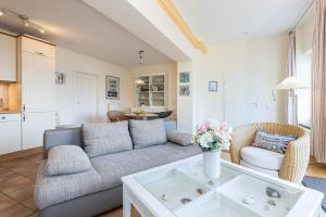 a living room with a couch and a table at Hafen 13 Hafenblick 1 in Laboe