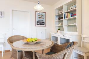a dining room with a table and chairs and a fireplace at Hafen 13 Hafenblick 1 in Laboe +28 photos