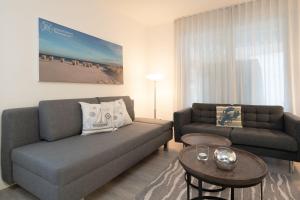 a living room with a couch and a table at Nien 2 Wildrose in Grömitz