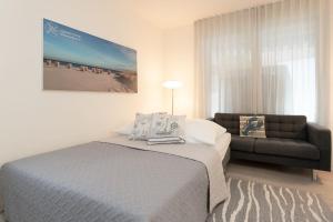 a bedroom with a bed and a couch at Nien 2 Wildrose in Grömitz