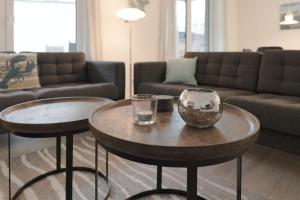 a living room with two tables and a couch at Nien 2 Wildrose in Grömitz +37 photos