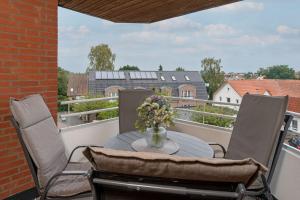 a table with a vase of flowers on a balcony at Haus Meeresgruß Relax in Grömitz