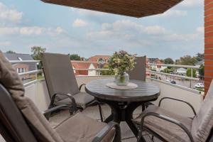 a patio table with chairs and a vase of flowers on a balcony at Haus Meeresgruß Relax in Grömitz +23 photos