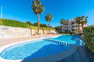 basen z palmami i budynek w obiekcie Sunnygolfbeach w mieście Orihuela Costa