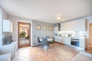 a kitchen with white cabinets and a table and chairs at ApartmentsGarda - Residence Bavaria in Pai +7 photos
