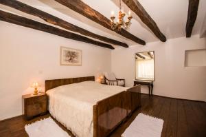 Schlafzimmer mit einem Bett und einem Kronleuchter in der Unterkunft Holiday Home Troštova Kuća in Pazin