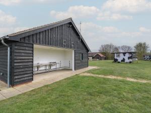 a large black barn with a large garage at Bluebelle Cow Shed 5 in Woodbridge