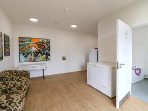 a living room with a couch and a refrigerator at Dozy Dotty Cow Shed 4 in Woodbridge
