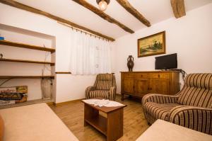 a living room with two chairs and a flat screen tv at Holiday Home Troštova Kuća in Pazin