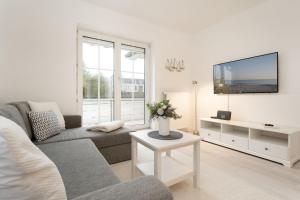 a living room with a couch and a tv at Ferienwohnung Jankar in Timmendorfer Strand +36 photos