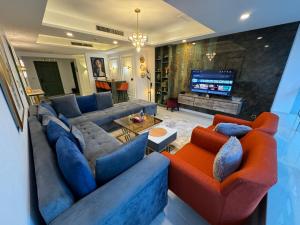 a living room with blue couches and a television at The Centaurus One, Two & Studio Apartments EasyStay in Islamabad