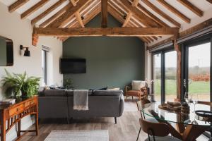 a living room with a couch and a table at Malvern, The Mount Barns & Spa in Elmley Lovett