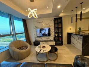 a living room with a chair and a table at The Centaurus One, Two & Studio Apartments EasyStay in Islamabad