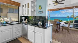 a kitchen with white cabinets and a view of the ocean at Kapalua Bay Villa 18G2 in Kapalua +29 photos