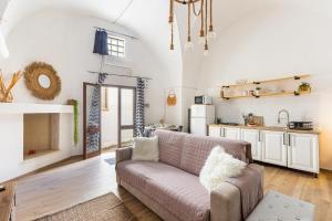 a living room with a couch and a kitchen at La Casetta a Sannicola by BarbarHouse in Sannicola