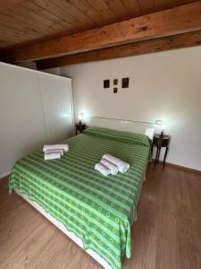 a bedroom with a green bed with two towels on it at Affaccio sul Mare in Tropea