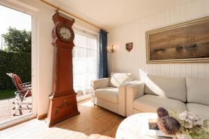 a living room with a grandfather clock and a couch at Ferienhaus Seepferdchen in Fehmarn