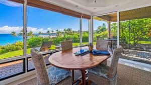a dining room with a table and chairs and the ocean at Kapalua Bay Villa 18G2 in Kapalua