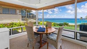 a dining room with a table and chairs and the ocean at Kapalua Bay Villa 18G2 in Kapalua