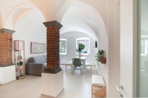 Una sala de estar con arco y un comedor. en Memories Garden, en Bérgamo