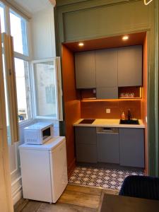 a kitchen with a microwave on top of a refrigerator at La Suite Historique au Coeur d'Ussel in Ussel