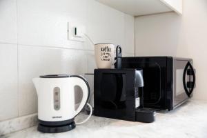 a kitchen counter with a coffee maker and a microwave at Casa di Pier&Chico in Genova