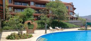 PaudThe Foresta Resort ,Mulshi的酒店楼前有游泳池