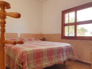 a bedroom with a bed with a plaid blanket and a window at Casa Estela in Alcanar +23 photos