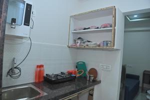 een aanrecht met een fornuis en een wastafel bij Modern 1 BHK in Kondapur in Prime Location #103 in Kondapur