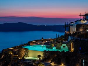 a view of a pool at night at Honeymoon Petra Villas in Imerovigli