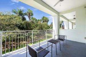 two chairs on a balcony with palm trees at Exclusive Doral Villa with Luxury Amenities in Miami