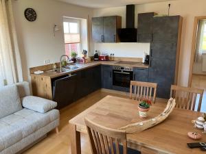 a kitchen and living room with a table and a couch at Wohnung mit Bergblick in Waging am See