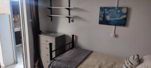 a bedroom with a bed and a dresser and a mirror at Habitacion Donde Emita in Santiago