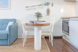 a dining room table with two chairs and a blue couch at Haus Baltic Traumfabrik in Scharbeutz