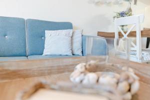 a living room with a blue couch and a table at Haus Baltic Traumfabrik in Scharbeutz