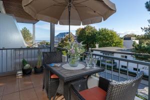 a table and chairs with an umbrella on a balcony at Haus Baltic Traumfabrik in Scharbeutz +24 photos