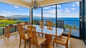 a dining room with a table and chairs and a view of the ocean at Kapalua Bay Villa 21G2 in Kapalua +33 photos