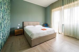 Un dormitorio con una cama y una ventana grande. en Tiber Domus Fiumicino - Apt 6, en Fiumicino 13 fotos más