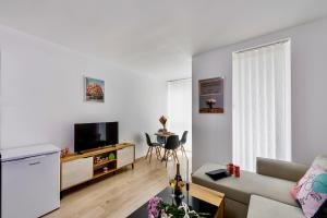 Una sala de estar con un sofá y un televisor. en Armand a là Dalia, en Sofía