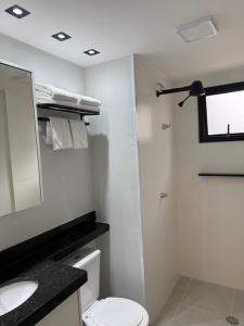 a bathroom with a toilet and a sink and a mirror at O melhor do Brooklin 1301 in Sao Paulo +9 photos