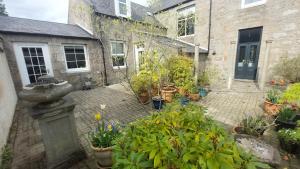 a courtyard with a bunch of potted plants at West Manse in Inverurie