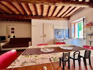 a room with a table and chairs and a kitchen at Casa Armonia - Elba Affitti in Rio nellʼElba