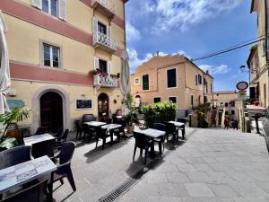 an outdoor patio with tables and chairs and buildings at Casa Armonia - Elba Affitti in Rio nellʼElba