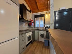 a kitchen with a sink and a washer and dryer at Descanso de posada in Posada de Llanes